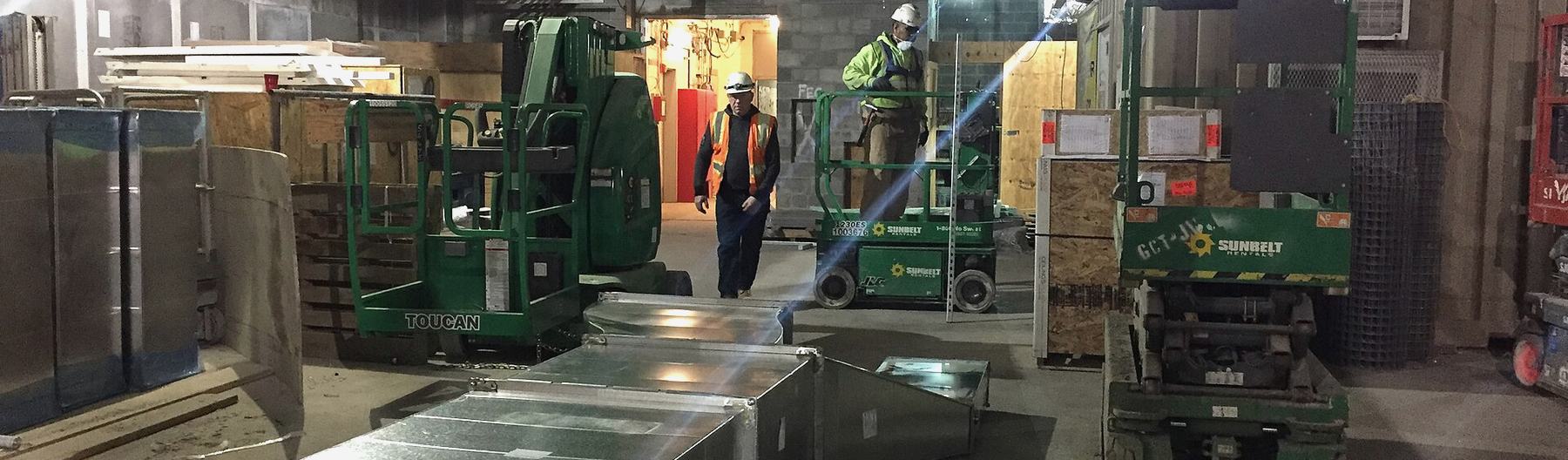Workers, lifts and staged material on an active job site